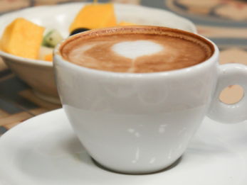 white ceramic cup with brown liquid inside